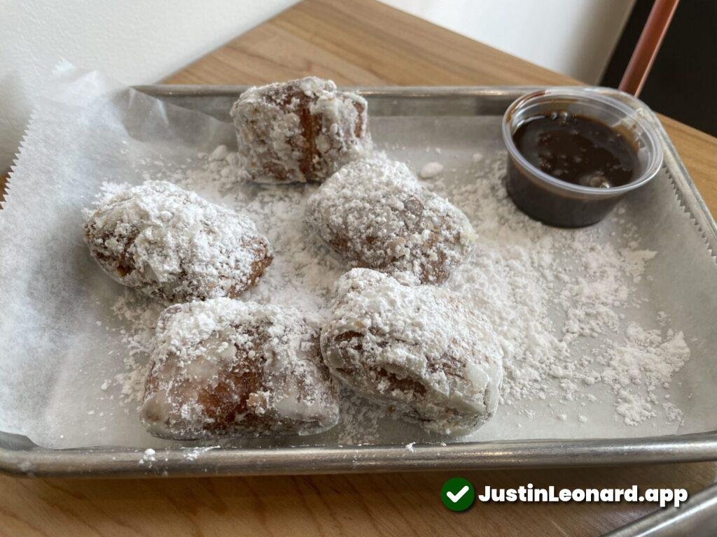 Tray with 5 beignets and chocolate dipping sauce